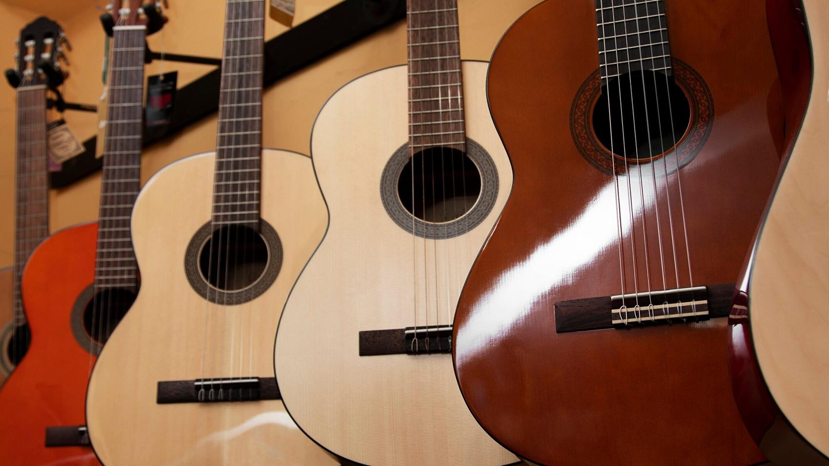 Fila de guitarras colgadas de la pared