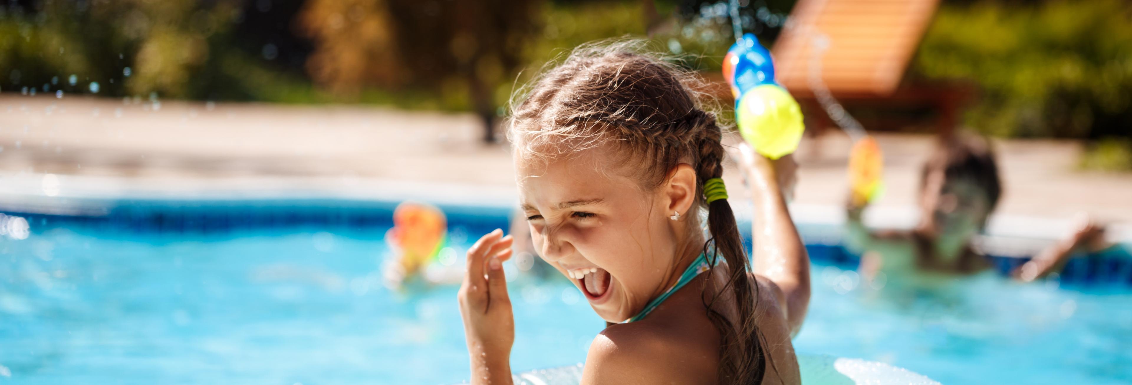 Niña jugando en la piscina Niña jugando en la piscina